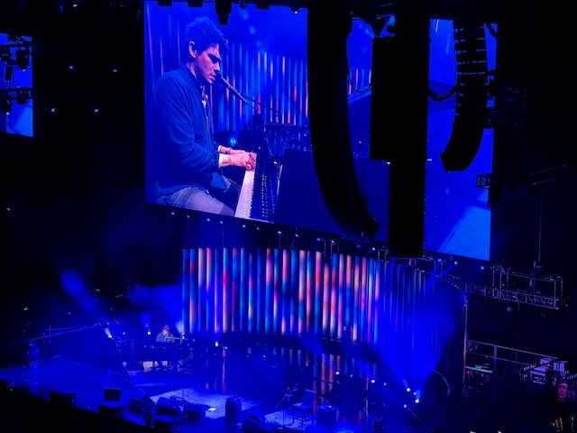 John sitting at the piano stage right playing