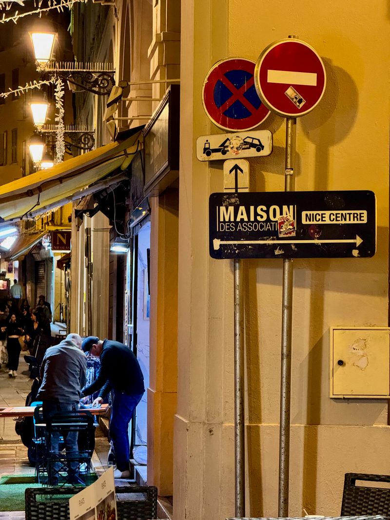 French traffic signs. people in background hunched over a table at night.