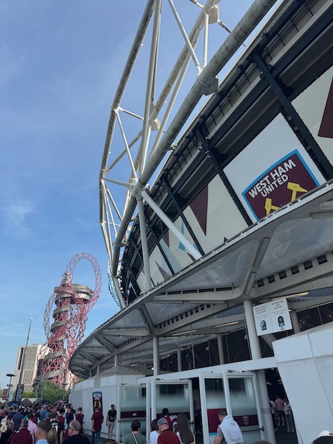 Outside of the London Stadium with the West Ham United crest on the side. The AcelorMittal Orbit is in the background