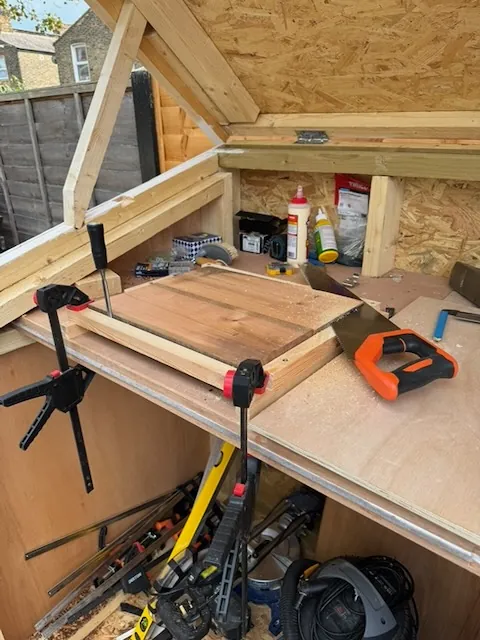 Using a hand saw to remove material from the guitar body.