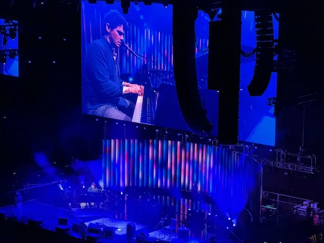 John sitting at the piano stage right playing