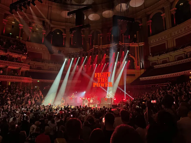 Wide shot of the stage. The text Fight the Power is on the screen behind the stage.