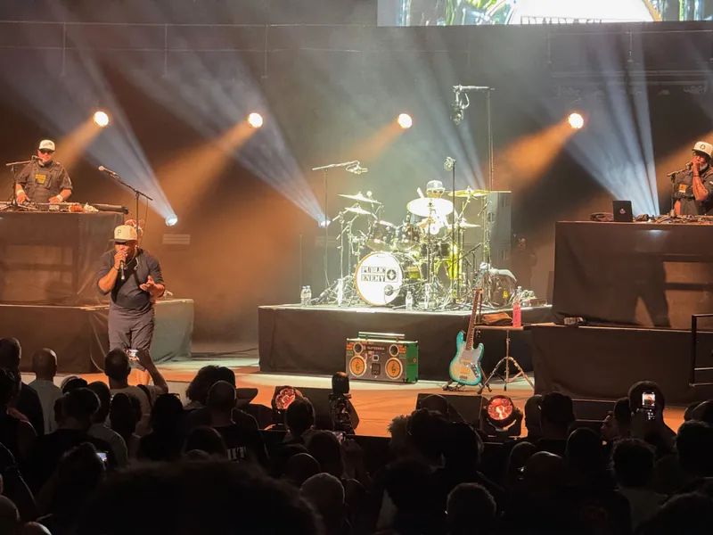 Flava Flav on the drums with Chuck D at the front of the stage.